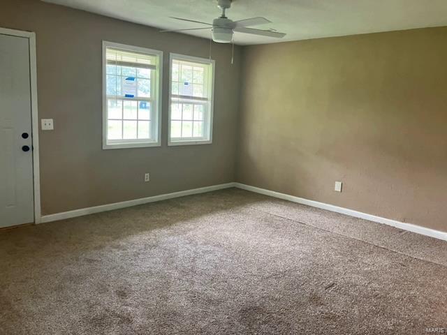 empty room featuring ceiling fan and carpet flooring