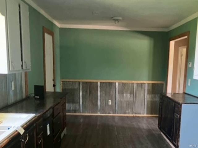 kitchen featuring dark wood-type flooring, crown molding, and dark brown cabinets