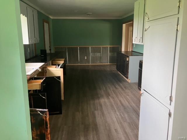 kitchen featuring white fridge, dark hardwood / wood-style flooring, ornamental molding, and green cabinetry