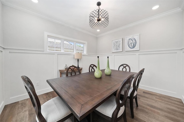 dining room featuring a wainscoted wall, ornamental molding, wood finished floors, a decorative wall, and recessed lighting