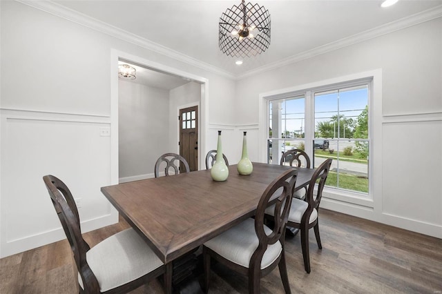 dining area with a notable chandelier, recessed lighting, a decorative wall, wood finished floors, and crown molding