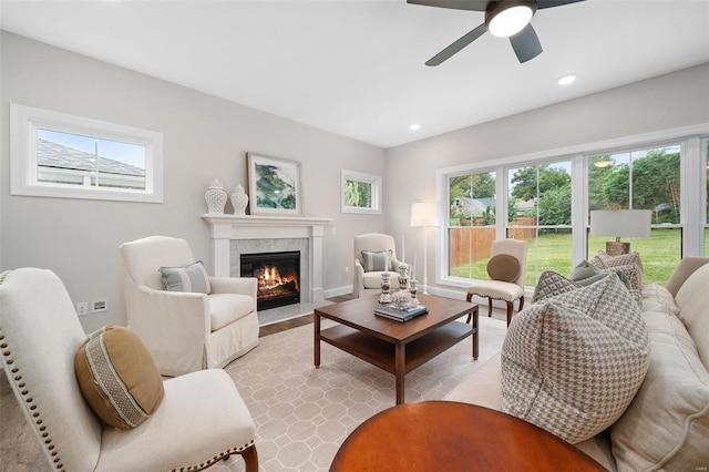 living room featuring baseboards, a tiled fireplace, a ceiling fan, and recessed lighting