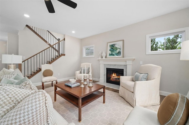 living room featuring light wood-type flooring, recessed lighting, baseboards, and stairs