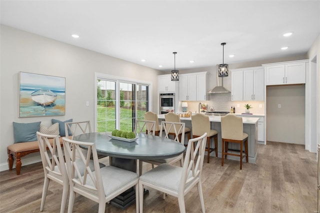 dining space with light wood-style flooring, baseboards, and recessed lighting