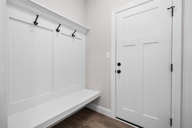 mudroom featuring dark wood-type flooring and baseboards