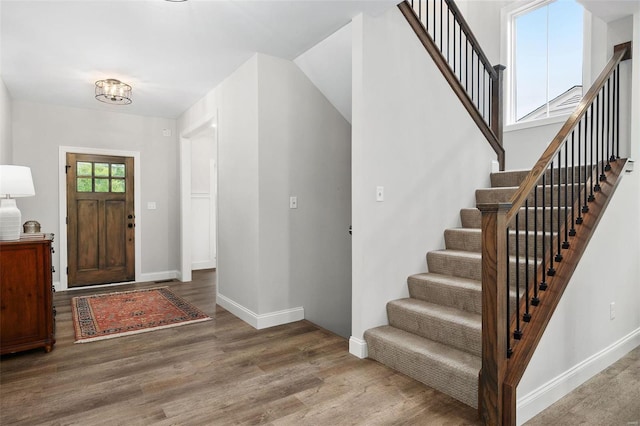 foyer with stairs, baseboards, and wood finished floors