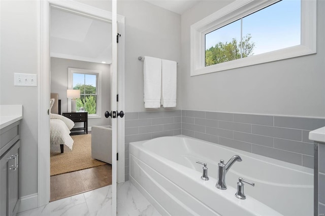 ensuite bathroom with marble finish floor, ensuite bath, a garden tub, and vanity