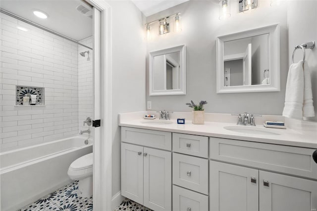 full bathroom with toilet, shower / tub combination, double vanity, and a sink