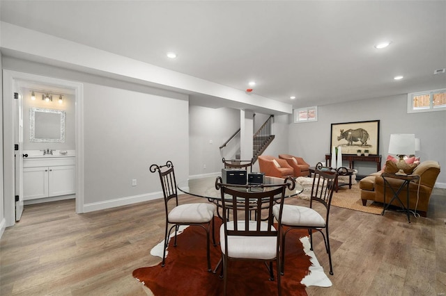 dining area featuring light wood-style flooring, stairway, baseboards, and recessed lighting