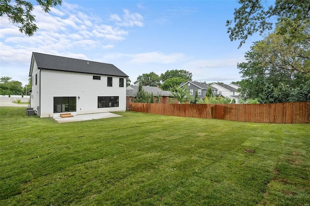 rear view of house with a patio area, cooling unit, fence, and a lawn