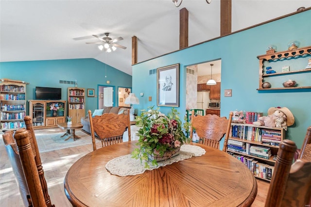 tiled dining room with ceiling fan and lofted ceiling