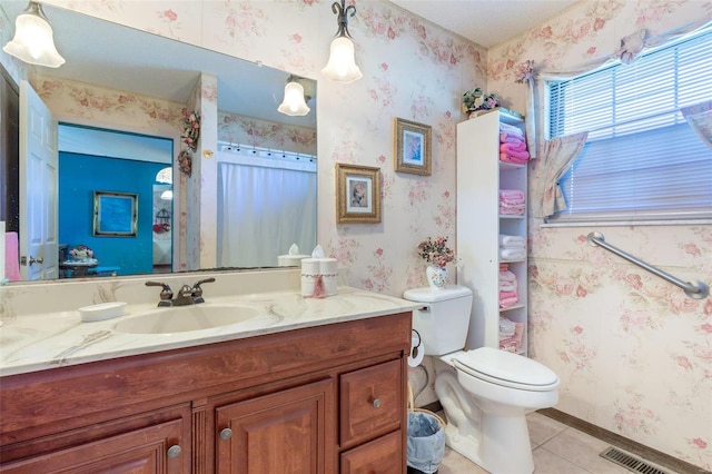 bathroom with tile patterned flooring, vanity, and toilet