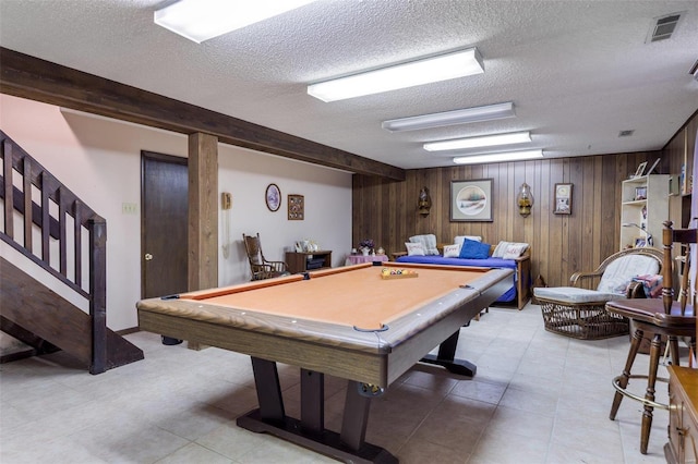 rec room featuring pool table, wooden walls, beam ceiling, a textured ceiling, and light tile patterned flooring