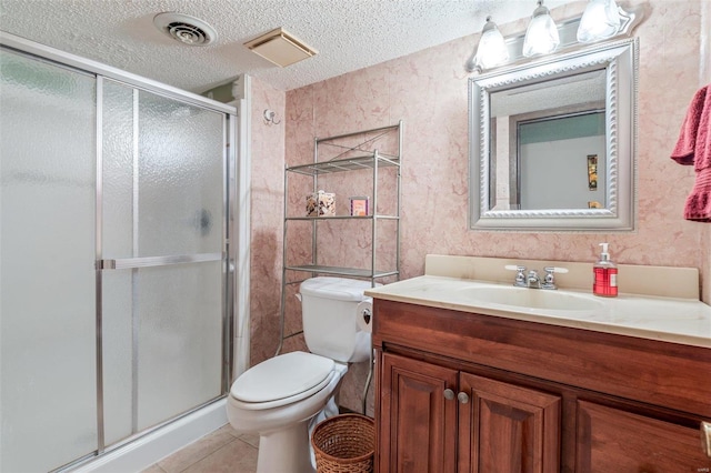 bathroom with toilet, vanity, tile patterned floors, walk in shower, and a textured ceiling