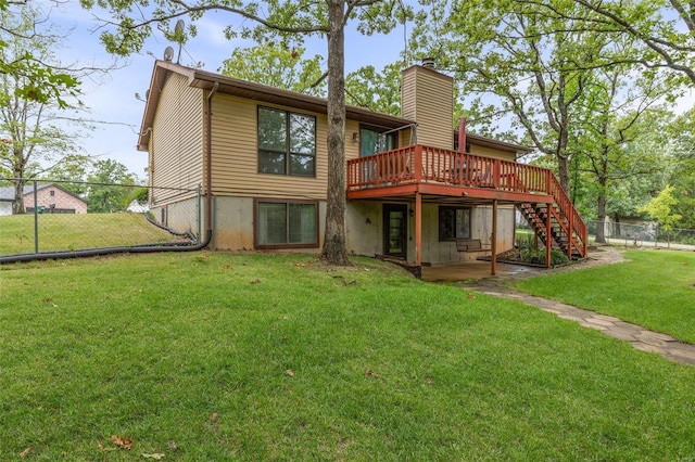 rear view of property featuring a wooden deck and a yard