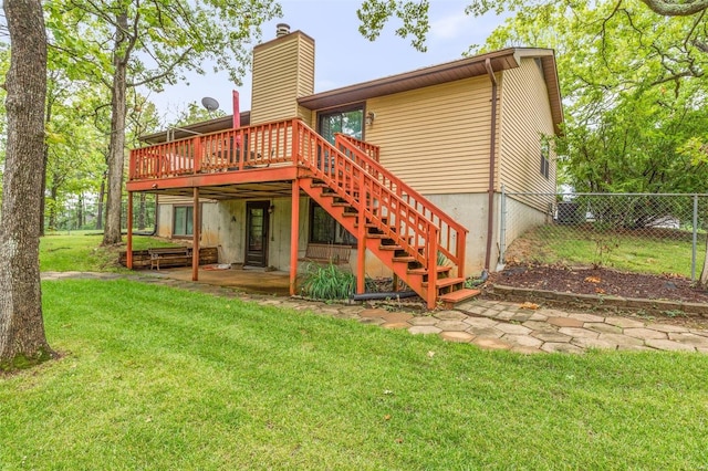 back of house with a deck and a lawn