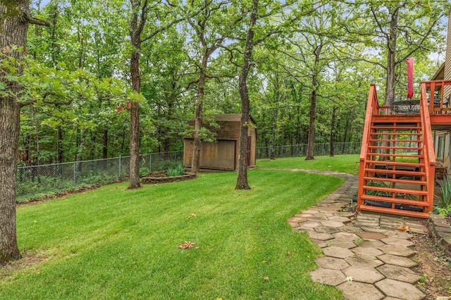 view of yard featuring a wooden deck and a shed