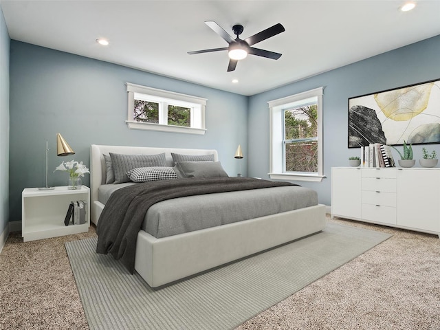 carpeted bedroom with ceiling fan and multiple windows