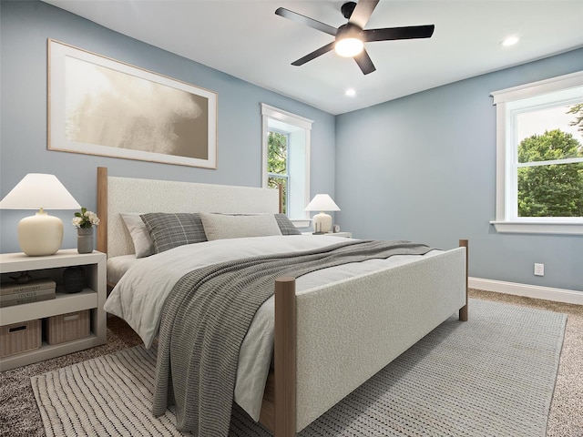 carpeted bedroom with multiple windows and ceiling fan