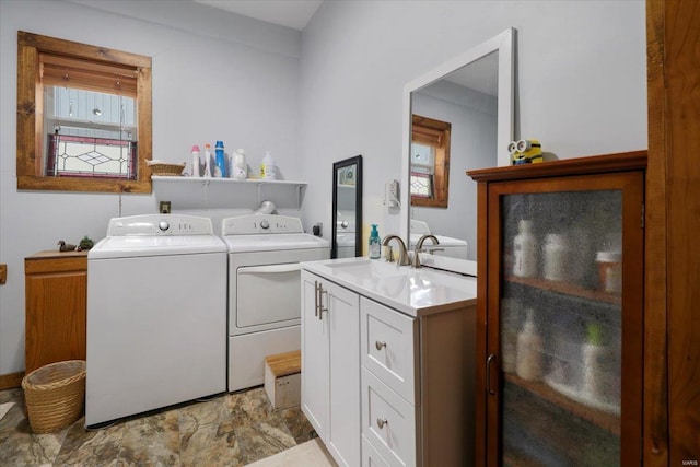 washroom featuring cabinet space, independent washer and dryer, and a sink