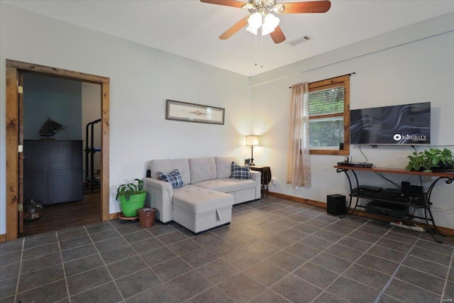 living area with visible vents, baseboards, dark tile patterned flooring, and a ceiling fan