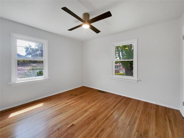 unfurnished room featuring hardwood / wood-style flooring, plenty of natural light, and ceiling fan