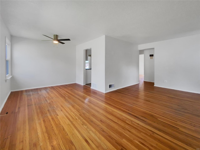 unfurnished room featuring wood-type flooring, ceiling fan, and a healthy amount of sunlight