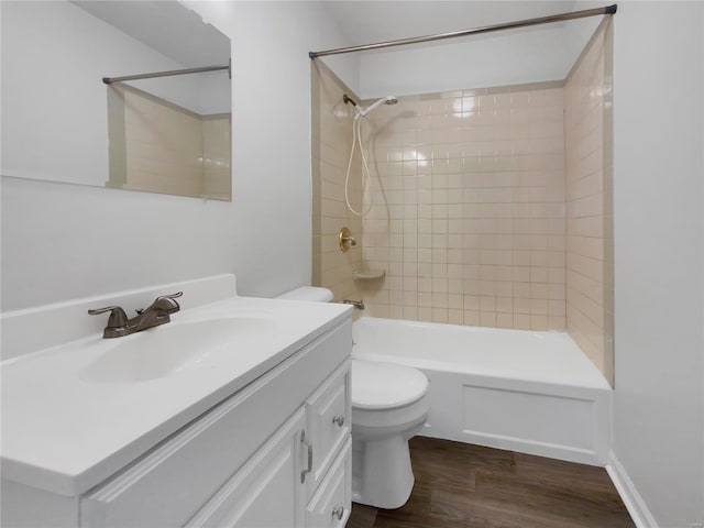 full bathroom with wood-type flooring, toilet, vanity, and tiled shower / bath combo