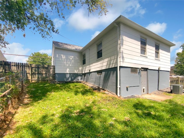 back of property with a yard and cooling unit