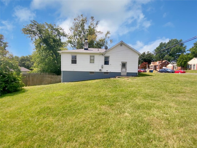 rear view of house featuring a lawn