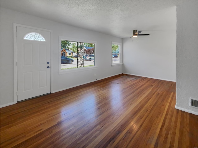 entryway featuring dark wood-type flooring, a textured ceiling, and ceiling fan