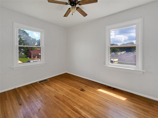 spare room featuring plenty of natural light and hardwood / wood-style flooring