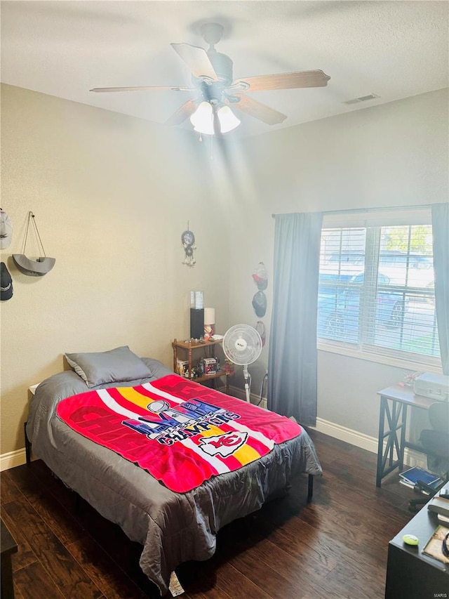 bedroom with dark hardwood / wood-style floors and ceiling fan