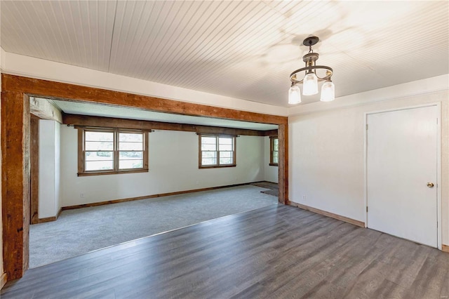 spare room featuring an inviting chandelier and wood-type flooring