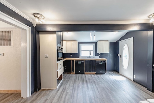 kitchen with wall oven, dishwasher, lofted ceiling, and a healthy amount of sunlight