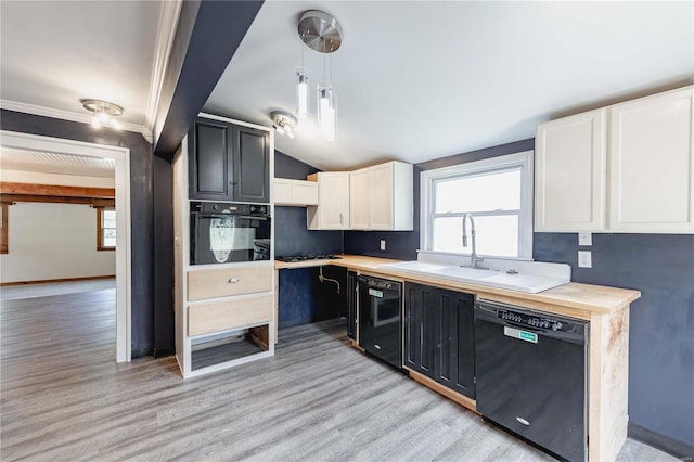 kitchen featuring pendant lighting, light hardwood / wood-style flooring, sink, white cabinets, and black appliances