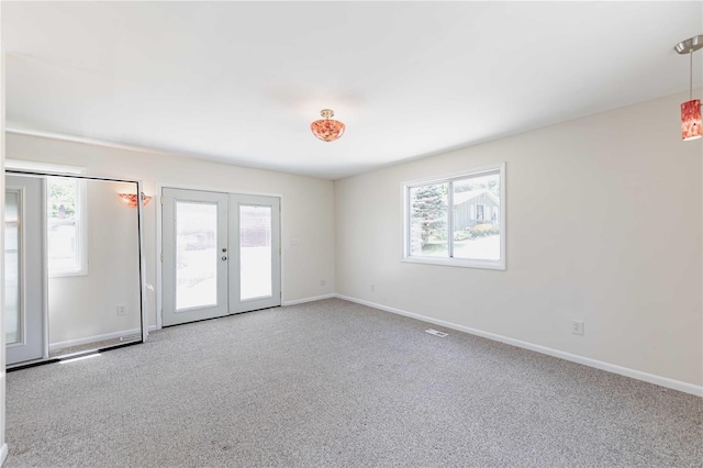 carpeted empty room featuring a wealth of natural light and french doors