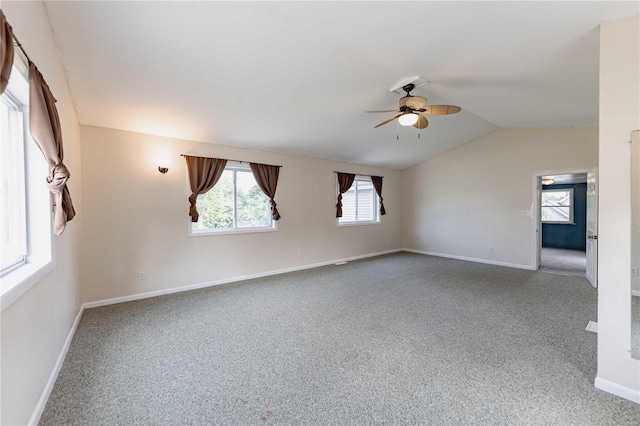 carpeted spare room featuring vaulted ceiling and ceiling fan