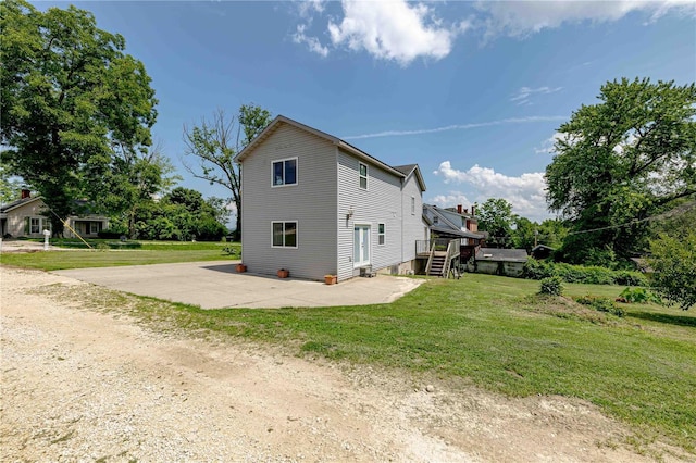 view of side of home with a patio area and a yard