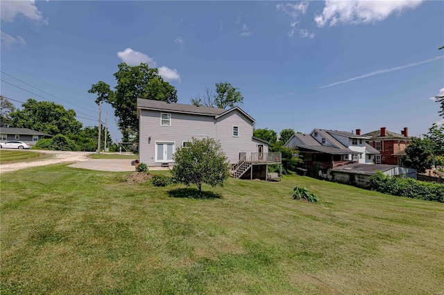 back of house featuring a patio area, a wooden deck, and a yard