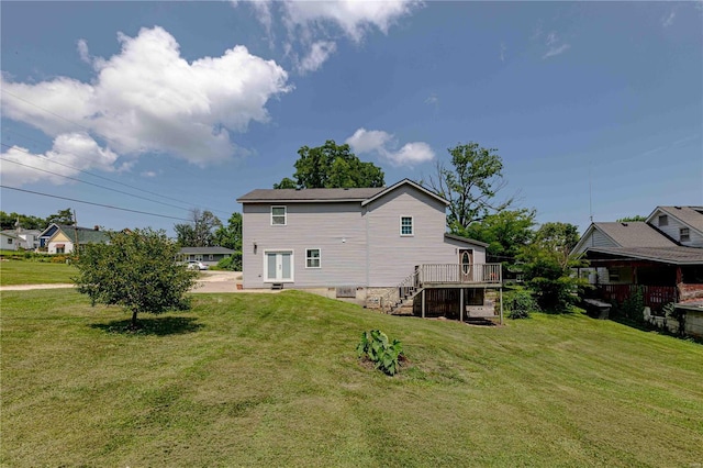 rear view of house with a wooden deck and a yard