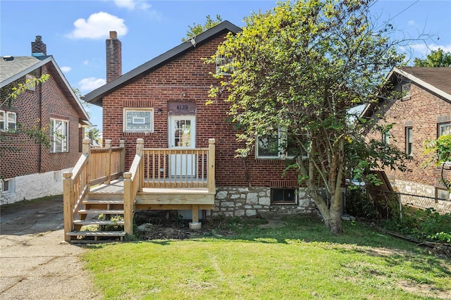 rear view of house featuring a deck and a yard