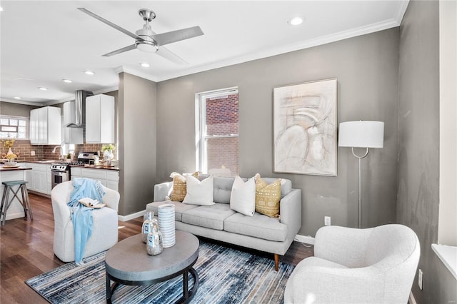 living room featuring sink, dark wood-type flooring, ornamental molding, and ceiling fan