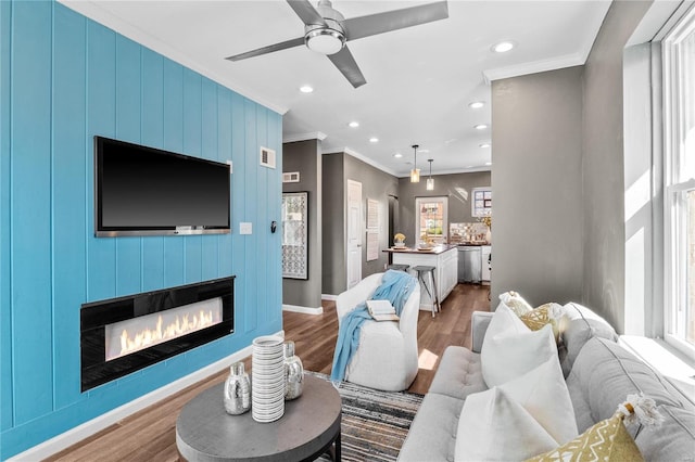 living room featuring ornamental molding, hardwood / wood-style floors, and ceiling fan