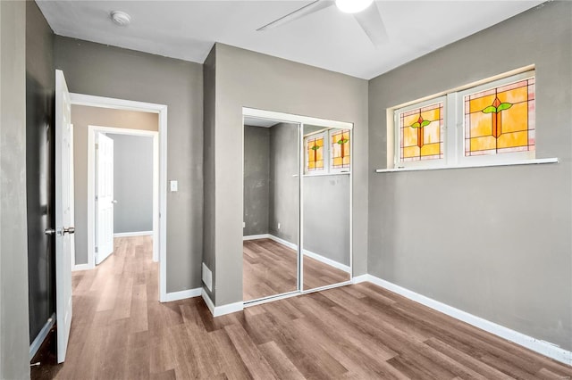 unfurnished bedroom with a closet, hardwood / wood-style floors, and ceiling fan