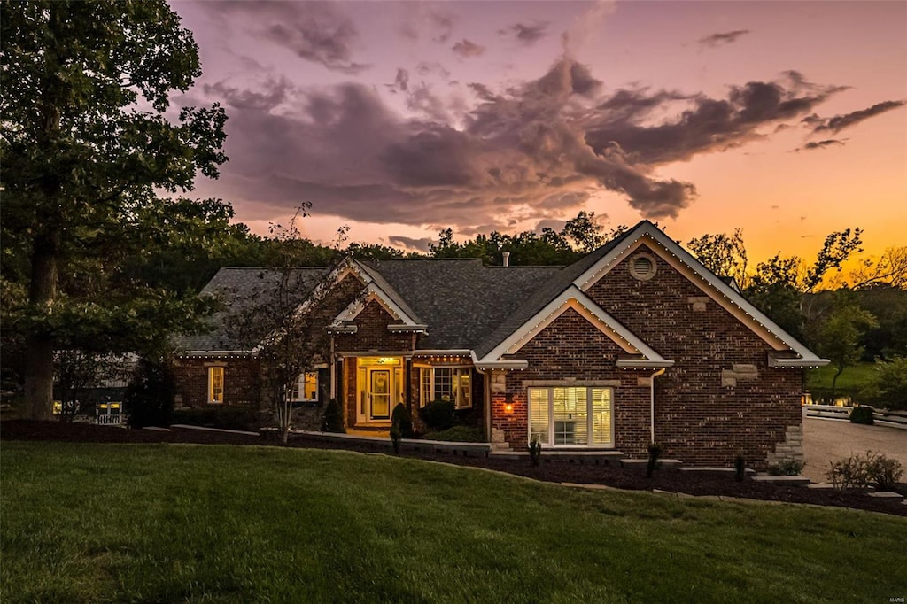 view of front of home featuring a front lawn and brick siding