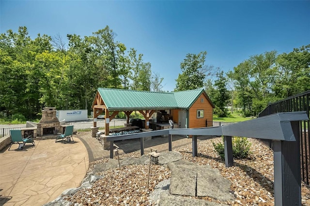 view of patio / terrace with a gazebo and an outdoor stone fireplace