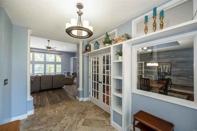 interior space featuring tile patterned floors, ceiling fan with notable chandelier, and french doors