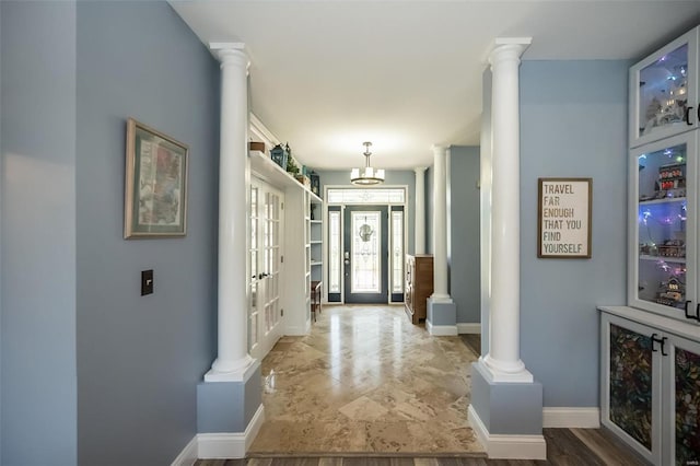 hallway with hardwood / wood-style flooring, ornate columns, and french doors