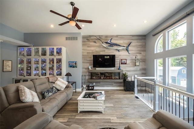 living room with a fireplace, ceiling fan, and light hardwood / wood-style floors